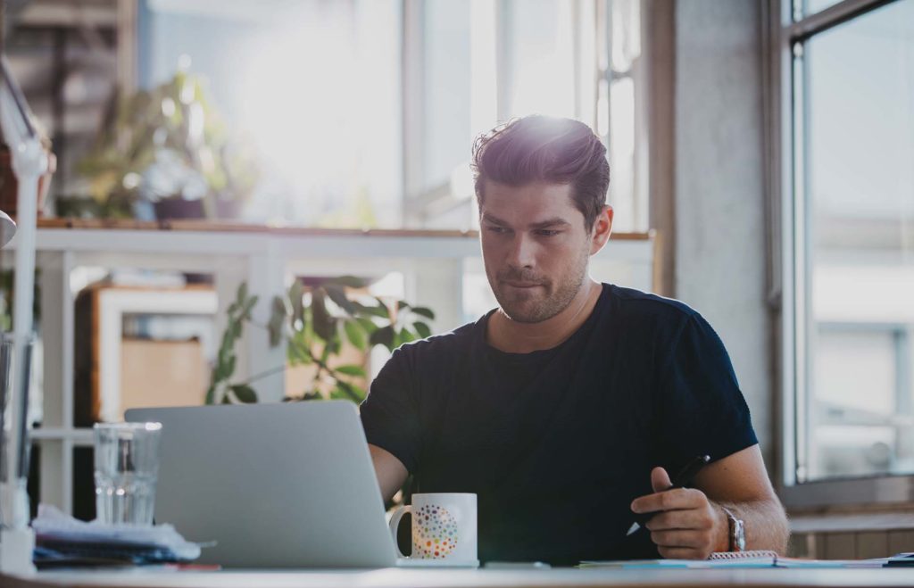 Handsome young businessman working at his desk Man laptop