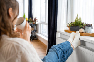 close-up-woman-sitting-near-heater